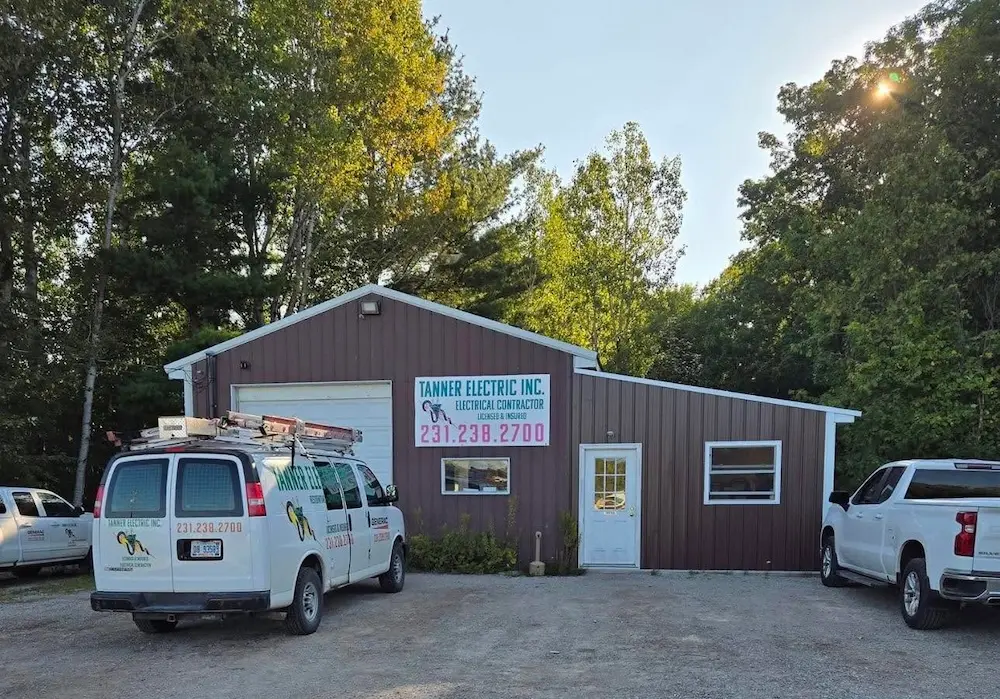 A Tanner Electric Inc. van and work truck sitting outside of the Tanner Electric Inc. offices located at 1351 S. Straits Hwy Indian River, MI 49749