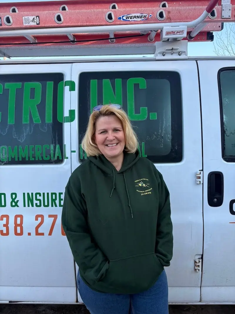 Donna Dingman, a member of the Tanner Electric Inc. team, wearing a Tanner Electric Inc. shirt and smiling.
