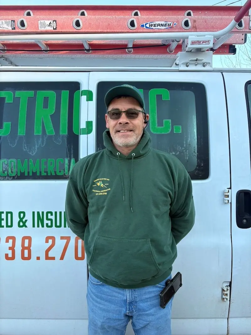 Jason Tanner, a member of the Tanner Electric Inc. team, wearing a Tanner Electric Inc. shirt and smiling.