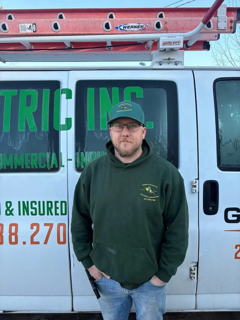 Josh Carr, a member of the Tanner Electric Inc. team, wearing a Tanner Electric Inc. shirt and smiling.