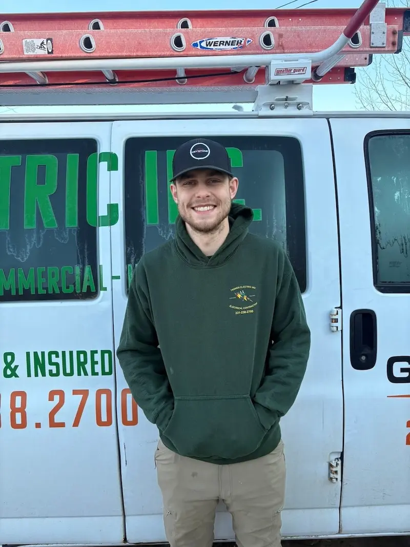 Lucas Parker, a member of the Tanner Electric Inc. team, wearing a Tanner Electric Inc. shirt and smiling.