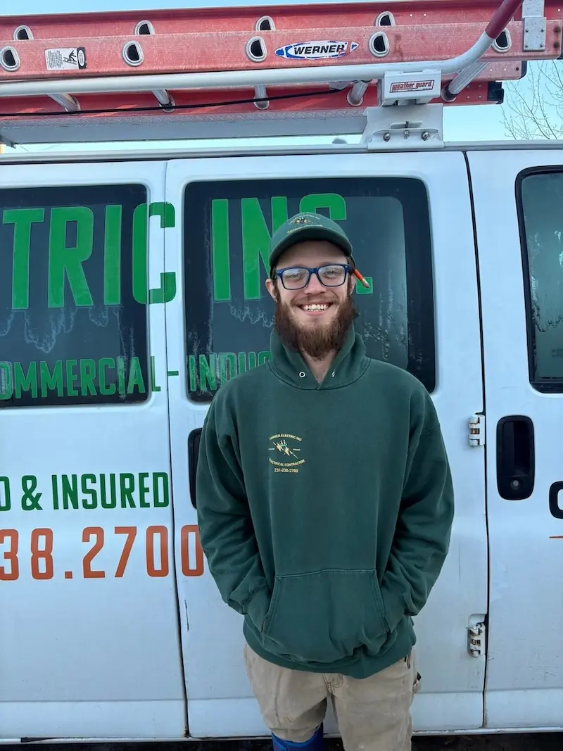 Will Seldon, a member of the Tanner Electric Inc. team, wearing a Tanner Electric Inc. shirt and smiling.